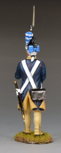 A painted toy soldier figurine of a Revolutionary War soldier in blue and tan uniform holding a musket upright, standing on a small patch of grass against a plain gray background.