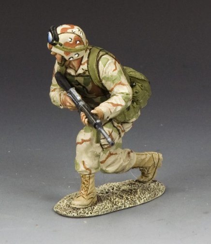 Crouching Ranger Moving Forward. military miniature figure in camouflage uniform with rifle on a gray background