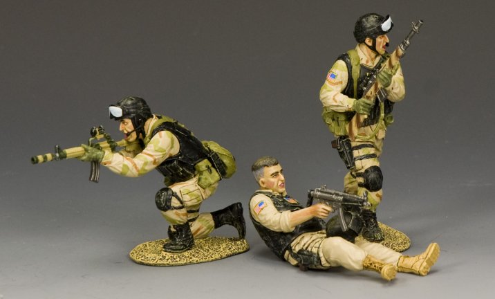 Three military figurines in action poses on a gray background