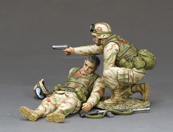 Stay down. Two toy soldiers in camouflage uniforms with one aiming a gun at the other on a gray background