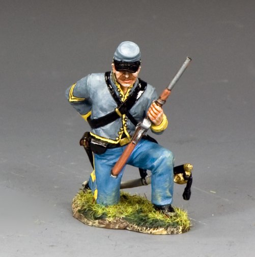 Military miniature of a kneeling Confederate corporal loading a carbine, wearing gray jacket and blue trousers with yellow trim.
