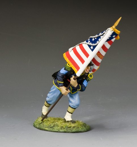 Toy soldier figure of a soldier holding an American flag on a gray background
