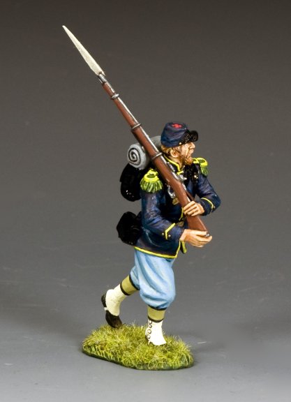 Model of a military miniature figure in uniform with a rifle on a gray background