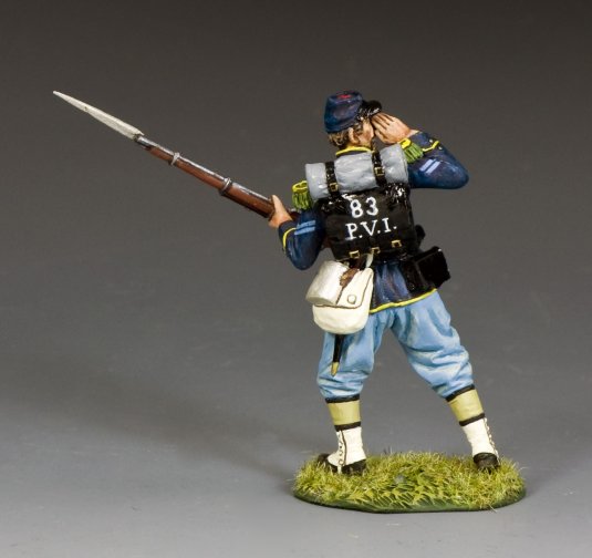 Model figure of a toy soldier with a rifle and backpack on a gray background