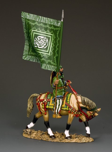 The Army of Islam Standard Bearer  on horseback carrying a large green flag with ornate Koranic script and Islamic geometric decoration.