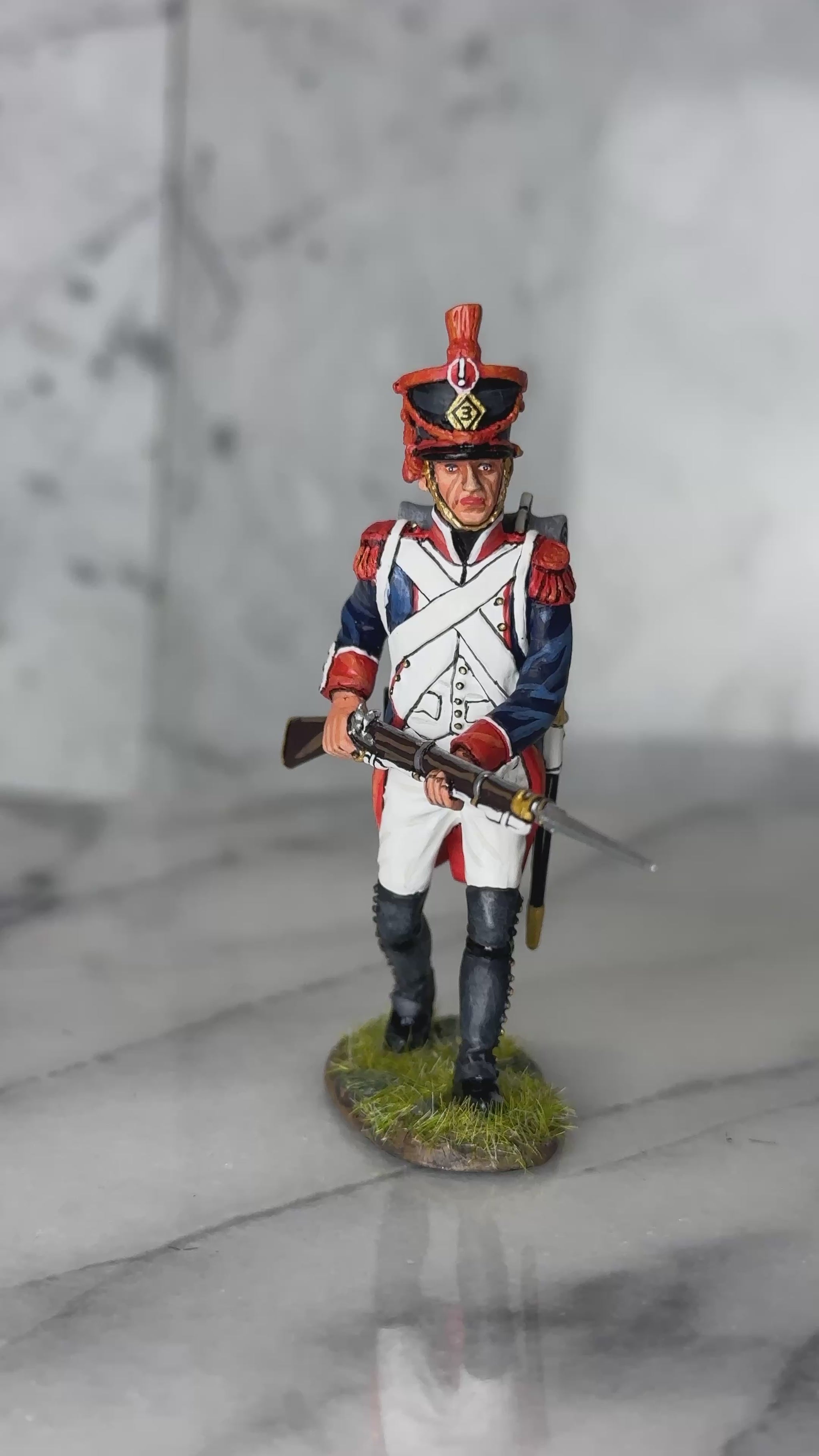 360 view of King & Country FLI Advancing w/Musket Levelled, French Light Infantry advancing with Charleville musket leveled at waist and bayonet forward, red plume shako, blue coat with red facings, 1/30 60mm matte figure, NA530