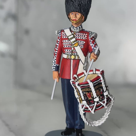 360 view of military miniature King & Country Scots Guards drummer — 1/30 scale matte-painted figure in scarlet ceremonial tunic, bearskin cap, with side drum. Catalog CE120.