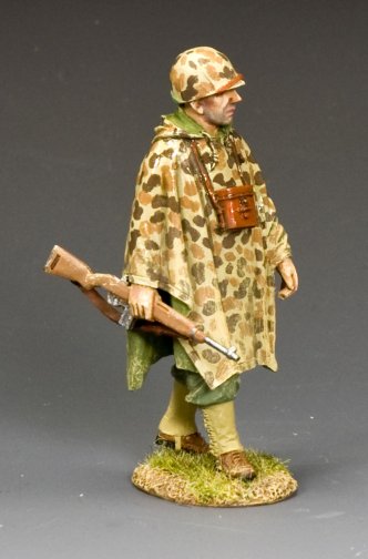 Model figure of a soldier in camouflage uniform with a rifle on a gray background
