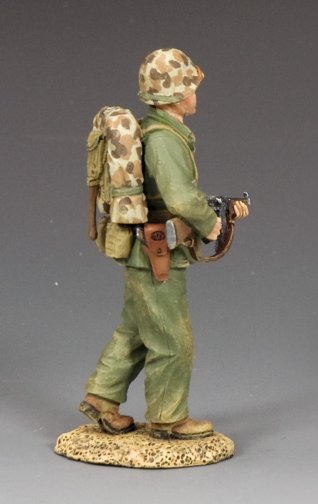 Walking Marine Sergeant. Toy soldier figure in military uniform with backpack and rifle on a gray background
