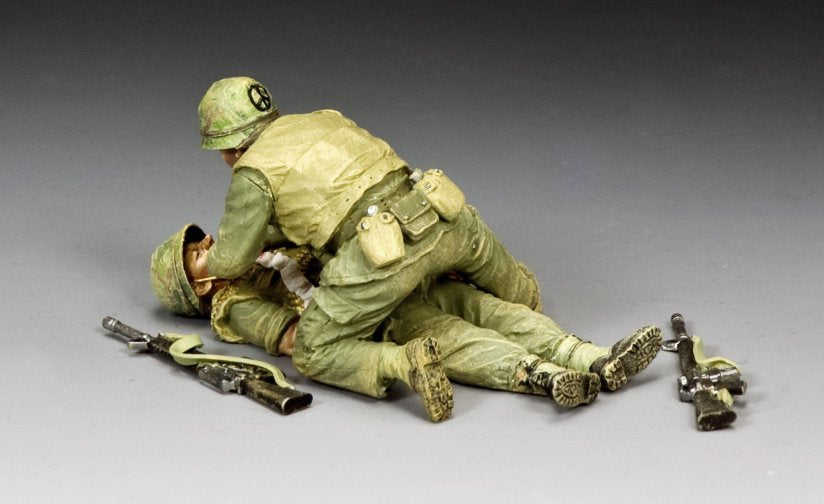 Wounded! Two toy soldiers military miniatures in a dynamic pose on a gray background