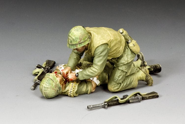 Wounded!. Two toy soldiers in a dynamic action pose on a gray background