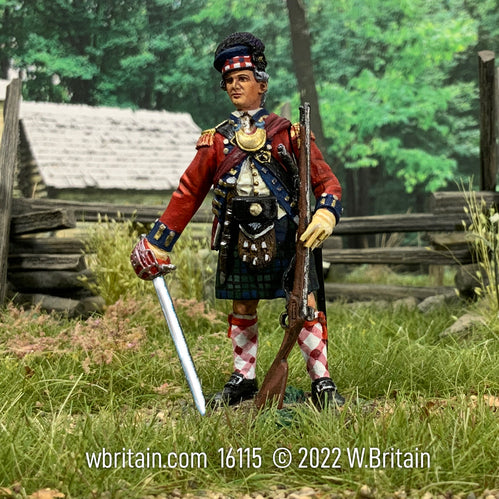 Collectible toy soldier with sword a musket standing in a field.