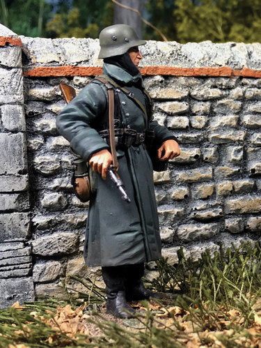 Toy soldier German Volksgrenadier Standing with Ammo Can. Standing near stone wall.