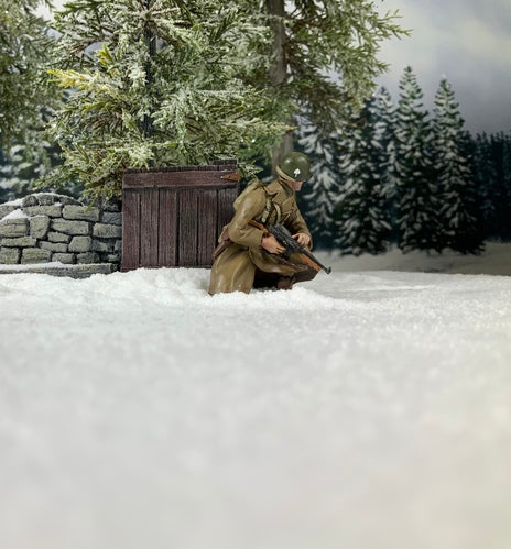 Collectible toy soldier miniature U.S. 101st Airborne in Greatcoat Kneeling with Thompson. He is in the snow.