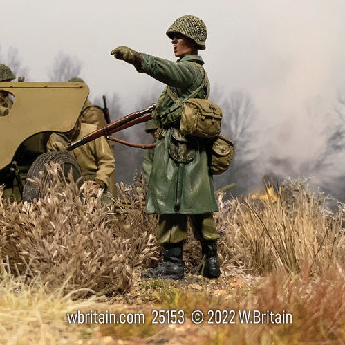 Toy soldier army men U.S. Infantryman in Raincoat Pointing. He is near a cannon.