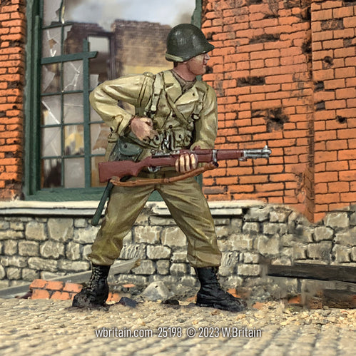 Toy soldier army men U.S. Armored Infantryman Reaching for Clip 1943-45. He is near a wall.